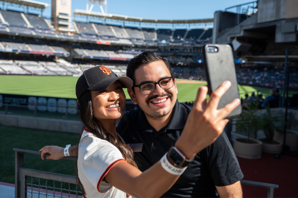 Two people taking a selfie at a baseball game