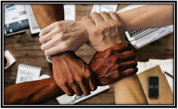 Diversely colored hands uniting as one collaborative fist.