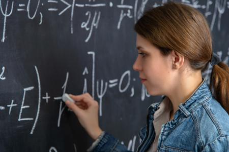 Student solving a math equation on a chalkboard