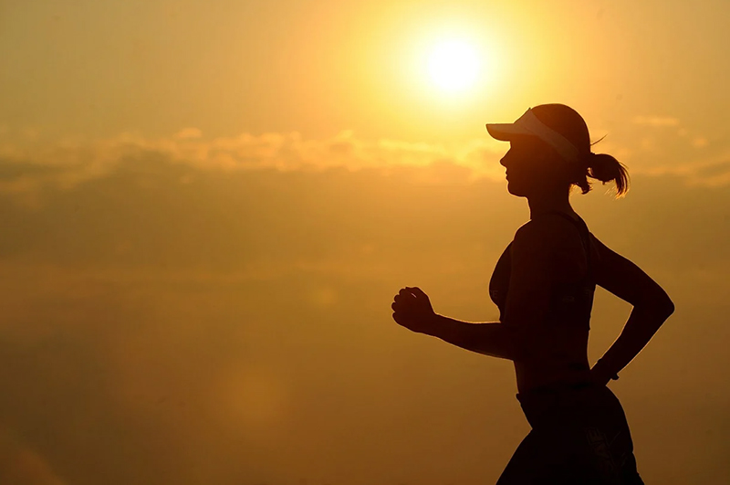 a woman going for a run at sunset