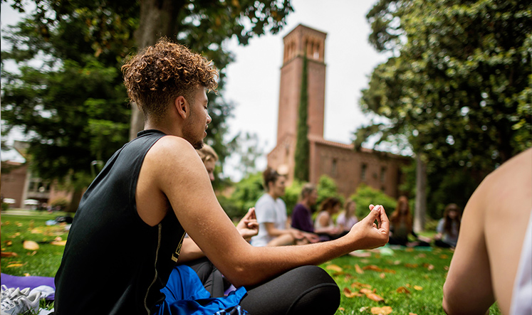 yoga class outdoor with campus bell tower in the background