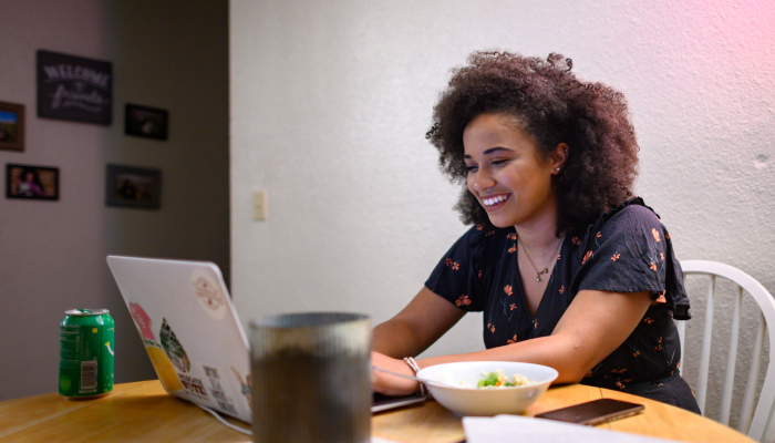 student works on a laptop at her kitchen table