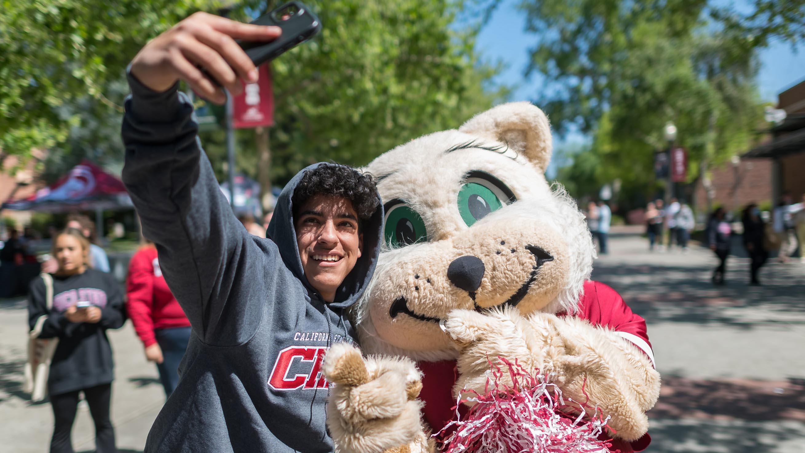 Student takes a selfie with Willie the Wildcat