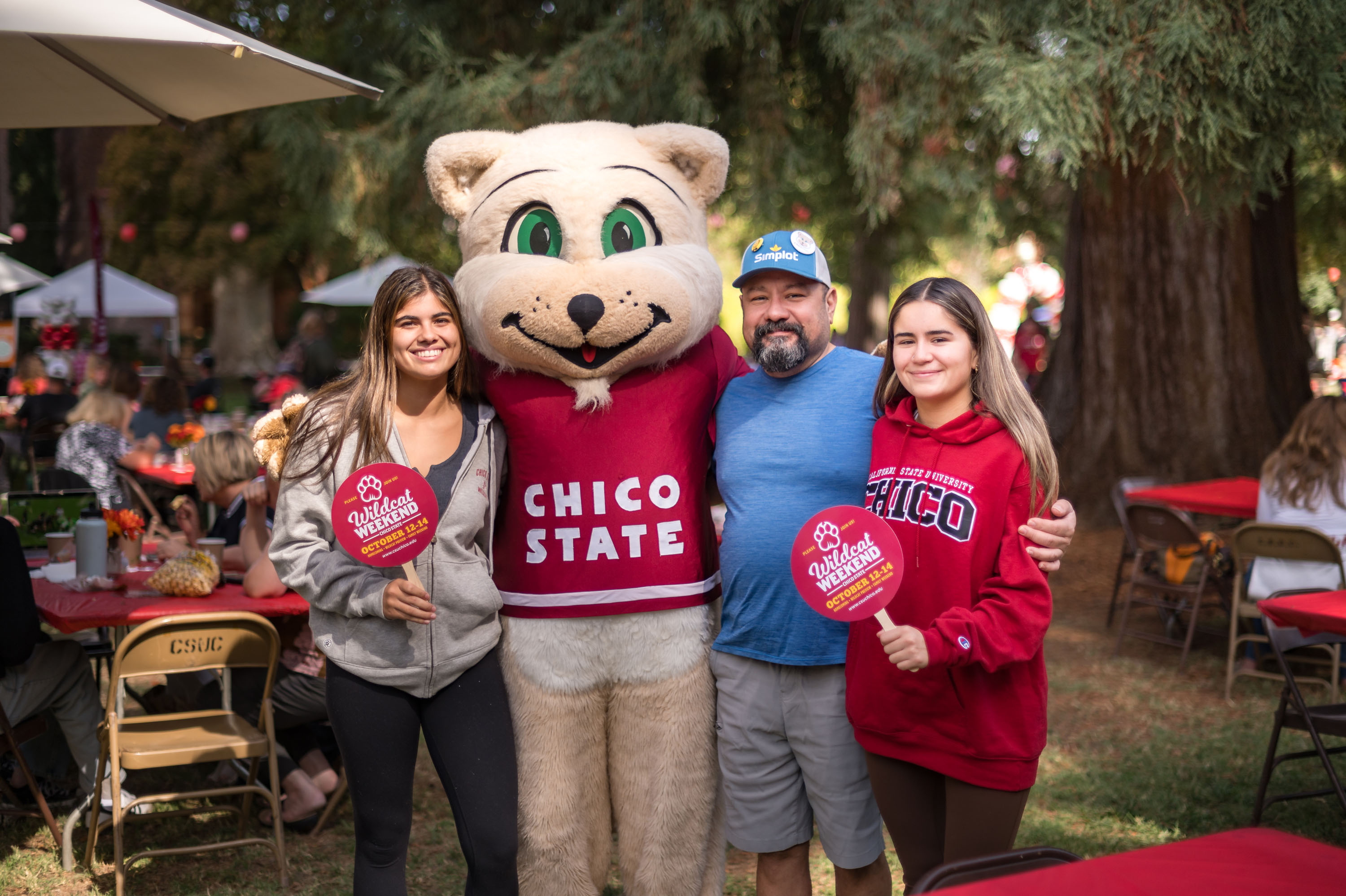family standing with wildcat mascot