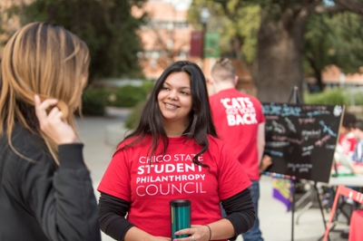 A student philanthropy council member talks with other students on campus.