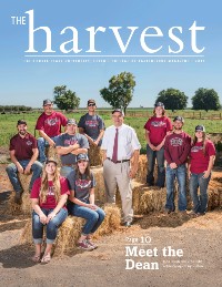 Magazine cover featuring dean and students posed among hay bales