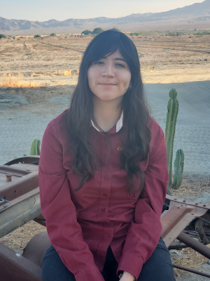 Student sits amid desert landscape