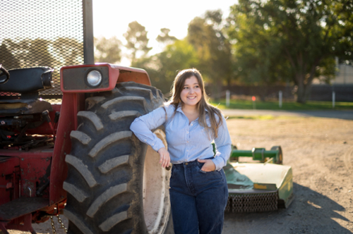 Student standing next to tractor. 