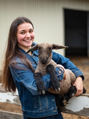 Student holding a baby lamb 