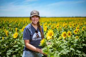 A student in a field of sunflowers