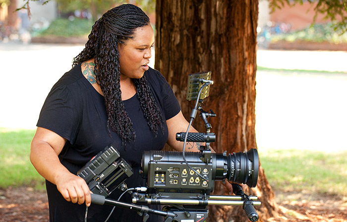 Student using expensive camera with CSU, Chico redwood tree in the background