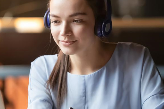girl wearing headphones, working on laptop from home