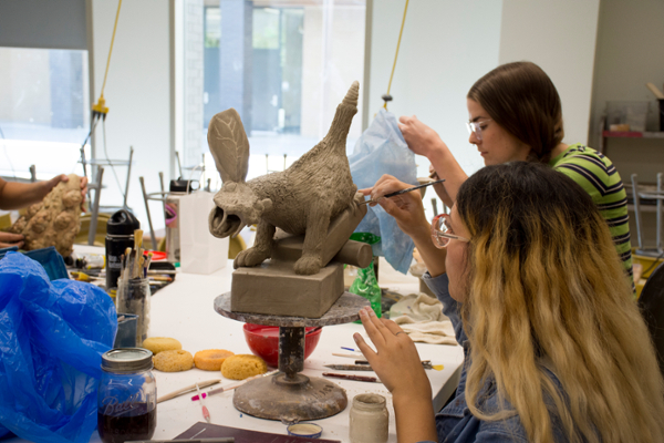 Students working on ceramics artwork.