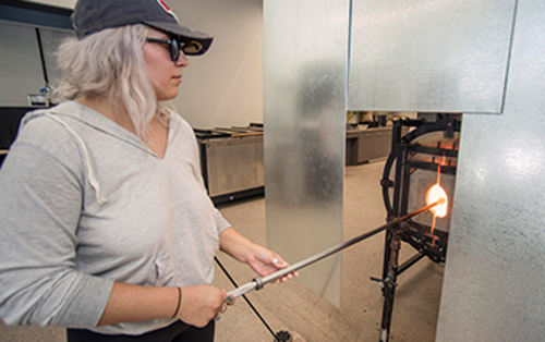 A girl working with molten glass