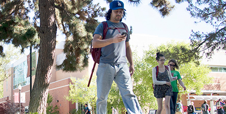 Students walk through campus on a sunny day