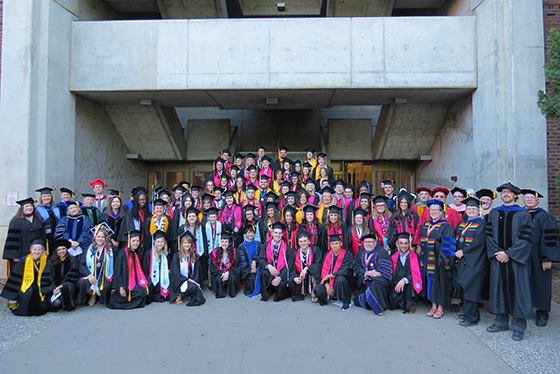 College of BSS, 2017 graduating class gathering outside Butte Hall in their cap and gowns.