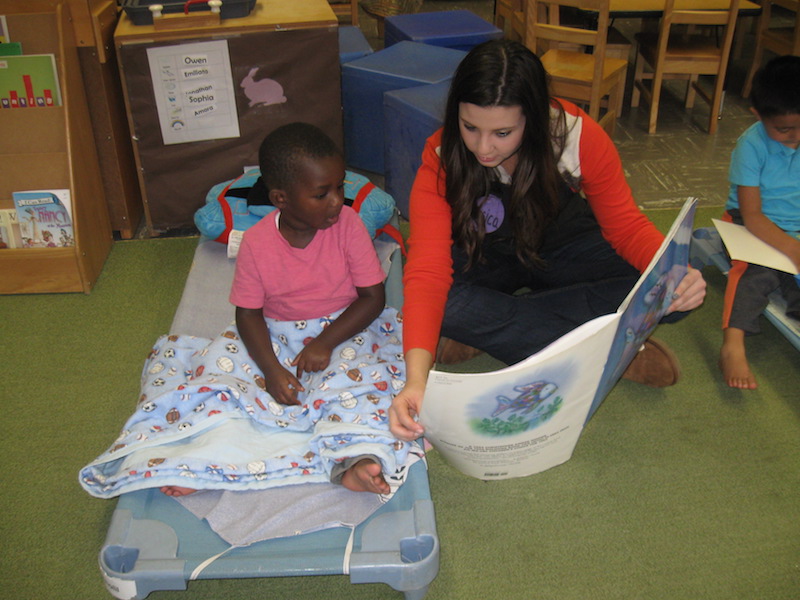 student reading book to child 