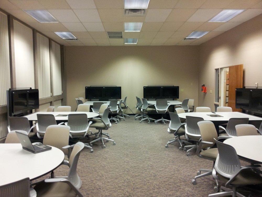 Rolling chairs surround tables equipped with individual screens for sharing in MLIB 442