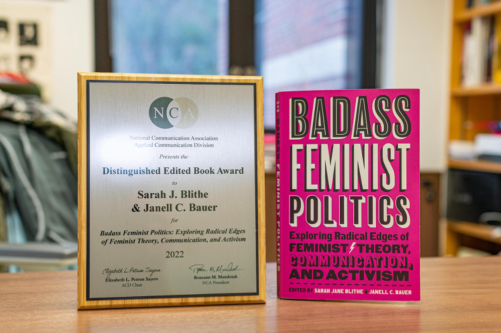 a book and a plaque with an award sit on a table
