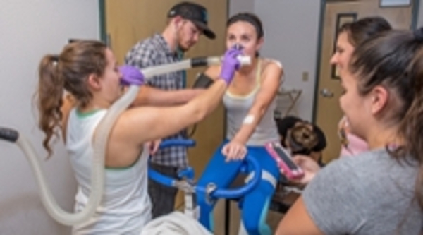 Students run various tests on a student using a stationary bike