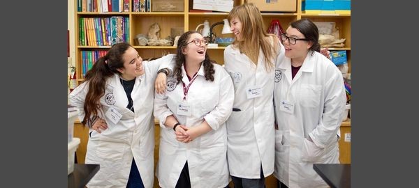 Four female student interns in the Hands on Lab, laughing.