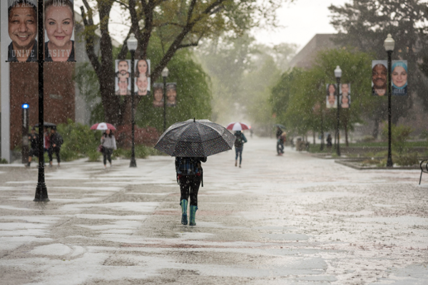 Students walk through the First Street Promenade as a thunderstorm brought in a lot of hail, rain and small flooding on campus on Thursday, April 13, 2017 in Chico, Calif. (Jason Halley/University Photographer)