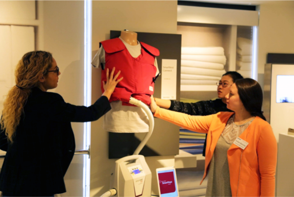 MBA students place their hands on a "Smart Vest" medical device currently in development at the Verizon Innovation Lab in San Francisco.