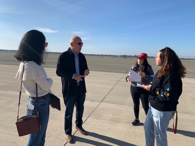 BT Chapman, Chico Airport commissioner, discusses details with Cleo Hadid (left), Stephanie Macias (middle, red hat), and Jessica Rodriguez (right).