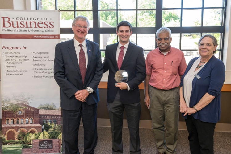 Finance students stand with their award in hand smiling with Finance and Marketing chair Richard Ponarul.