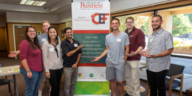Students involved with the Center for Excellence in Finance pose in front of a CEF sign