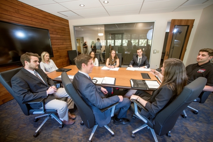Students working around a conference table in the Professional Sales Lab