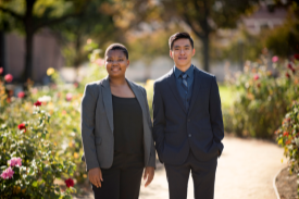 Two students pose for a photo in professional business attire.