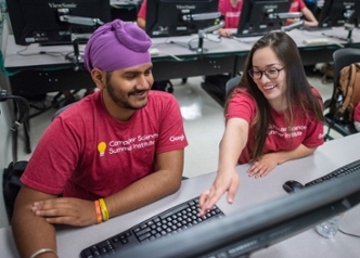 student assisting other student in computer
