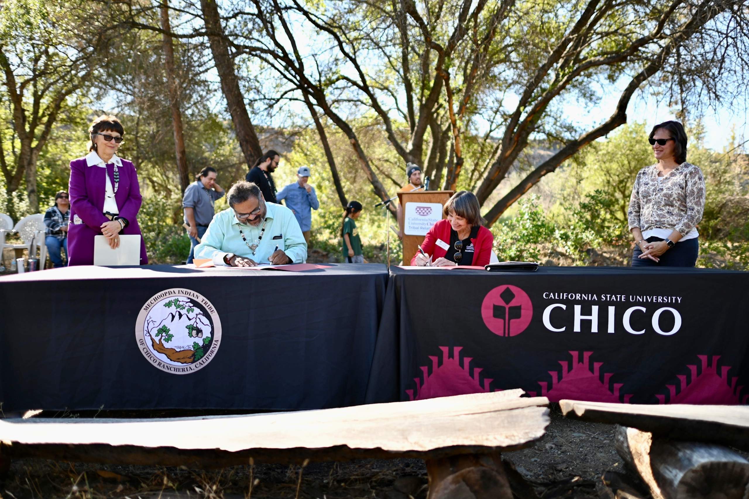 From left: Chico State President Gayle Hutchinson looks on as Mechoopda Tribal Chairman Dennis Ramirez and Chico State Provost Debra Larson sign the celebratory agreement documents to recognize the completion of the land transfer, as Wildlife Conservation Board Assistant Executive Director Rebecca Fris watches nearby.