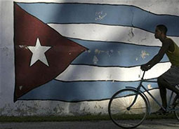 silhouette of man riding bike in front of Cuban flag