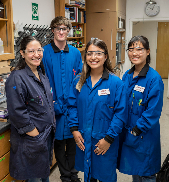 students in a blue lab coat standing