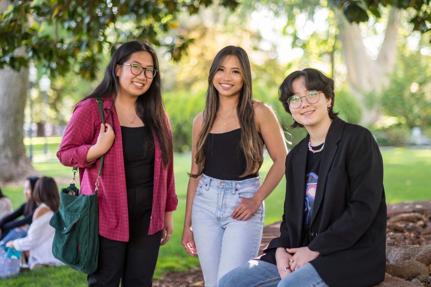 A group of API students smile and pose on campus