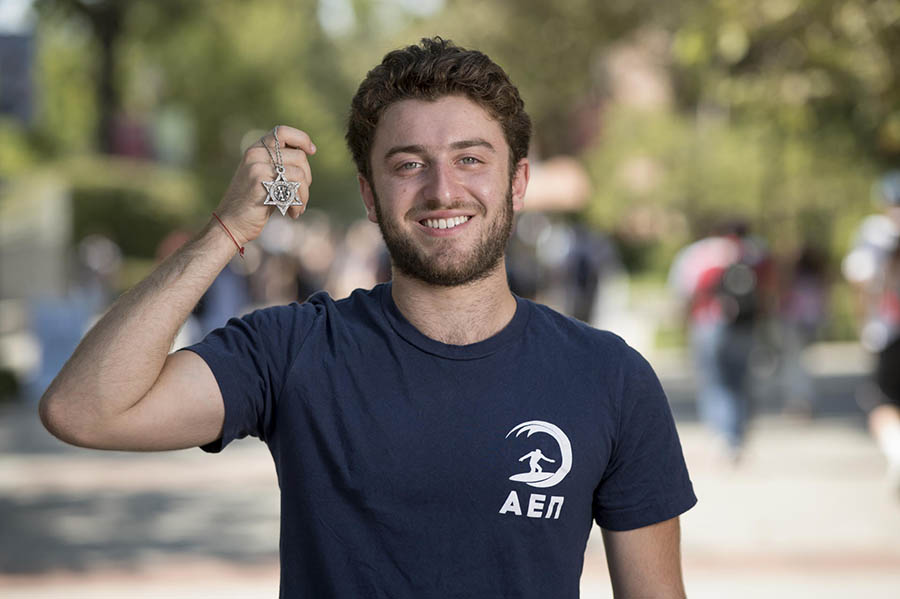 Smiling student holds up a Star of David necklace