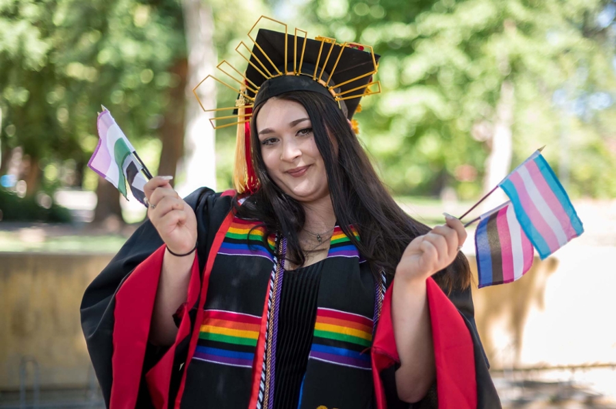 A student waves a rainbow flag at Lavender Graduation