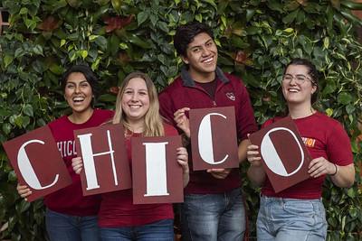 Five Chico State students holding a Chico sign with pom poms