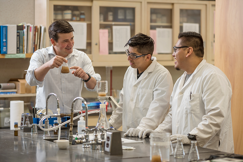 Professor and two students conducting an experiment