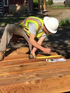 A construction management student measures a beam
