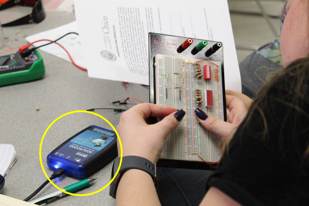 student in circuits with portable instrument