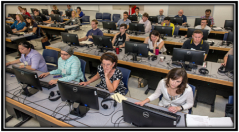 Multiple faculty working in a computer lab.