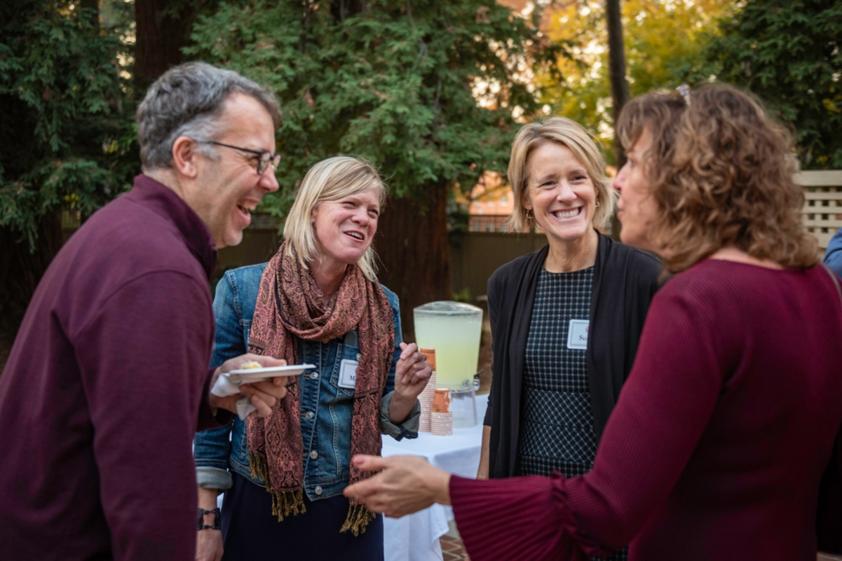 faculty smiling while socializing during the 2019 Newly Promoted Faculty reception.