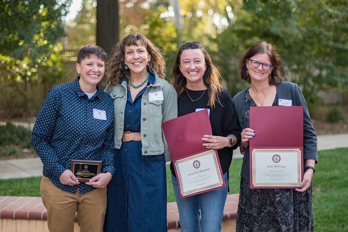 faculty smiling and holding awards during the 2022 tenure and promotion faculty reception.