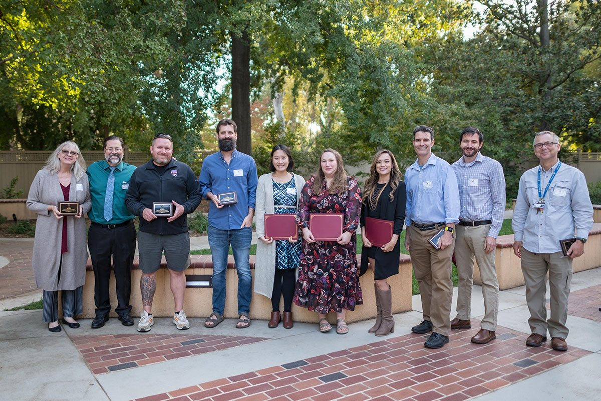 faculty posing and holding up awards during the 2022 tenure and promotion faculty reception.