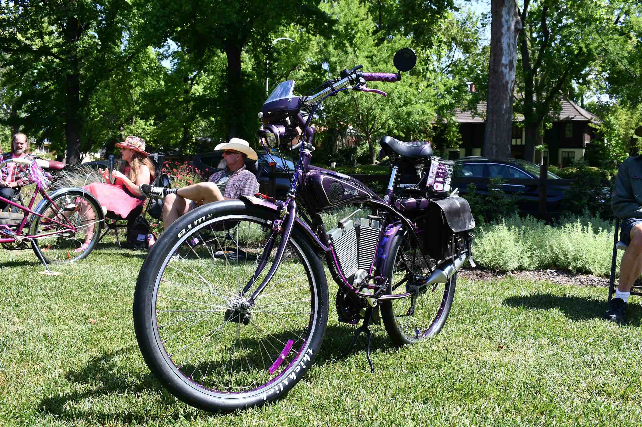Purple bike similar to a motorcycle propped on grass