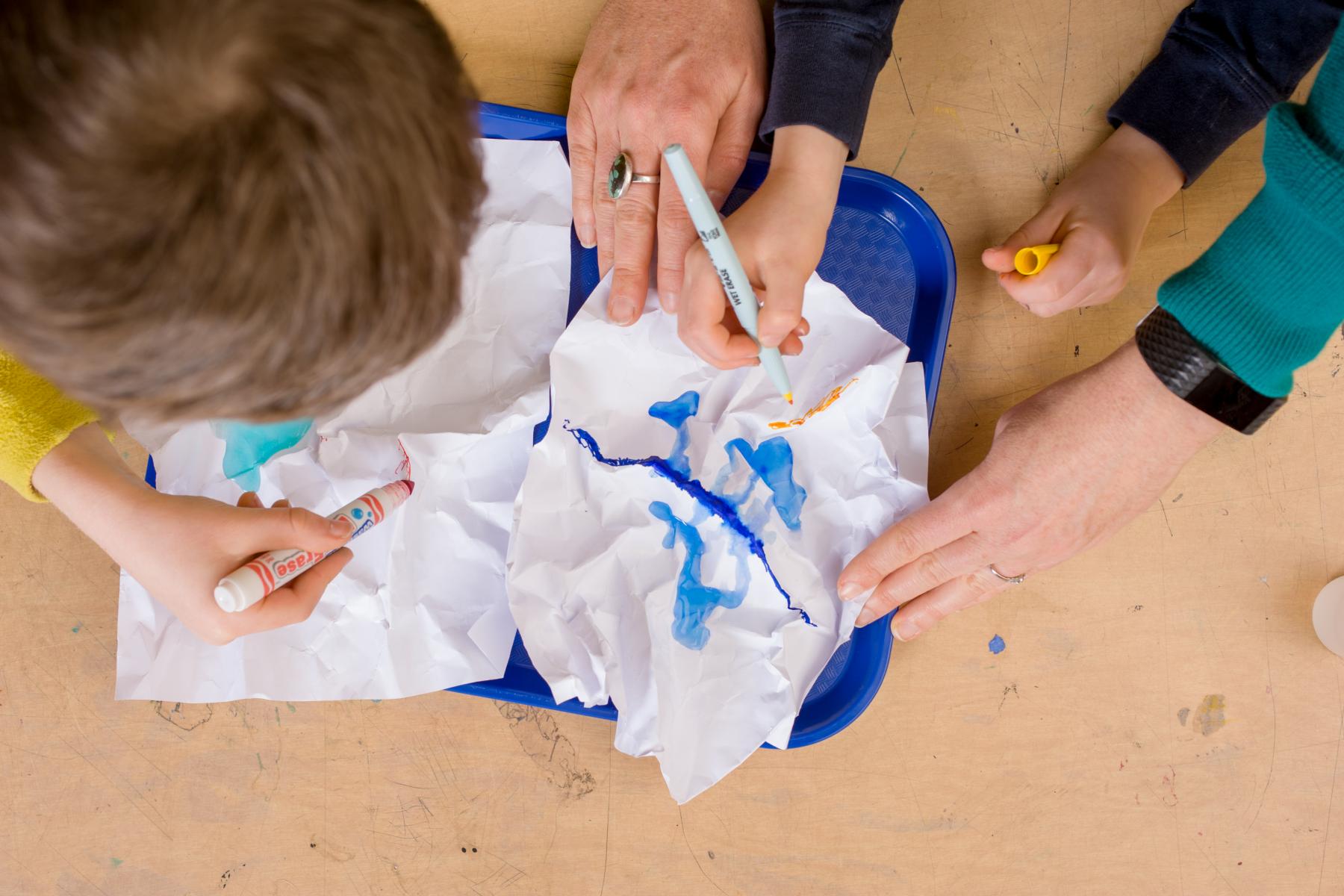Children color on crumpled paper
