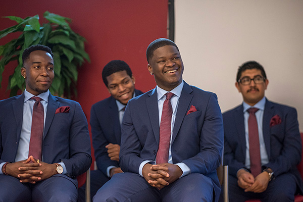 male students in suit and tile smiling